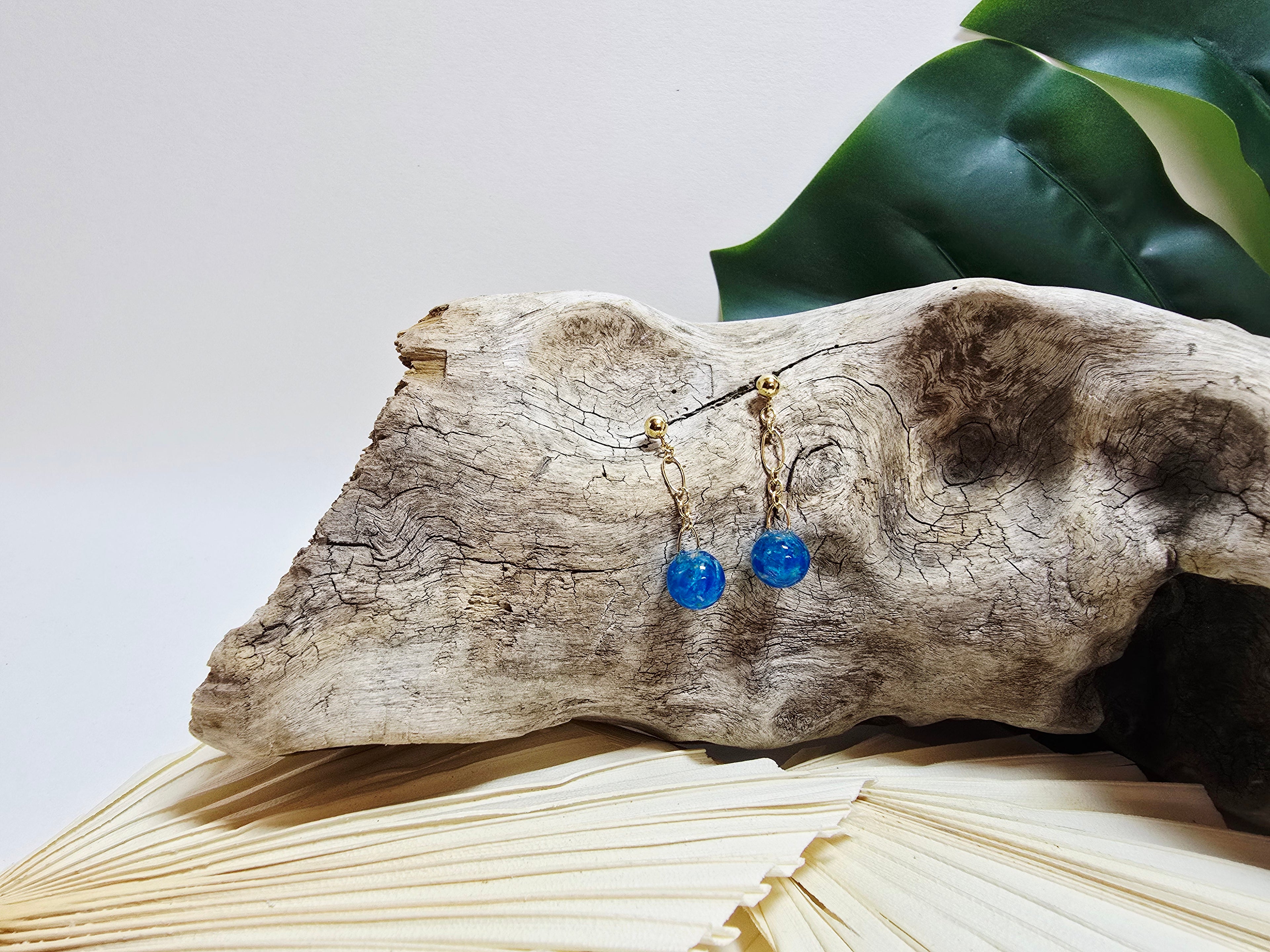Seren - boucles d'oreilles sphères chalcantite bleu électrique sur bois flotté et monstera, vue d'ensemble